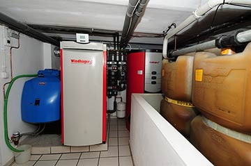 Moderne Ölheizung im Keller eines Wohnhauses, rechts im Bild die Öltanks