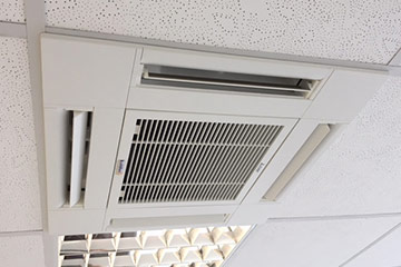 Eine Klimaanlage, die in eine Kassettendecke eingelassen ist.